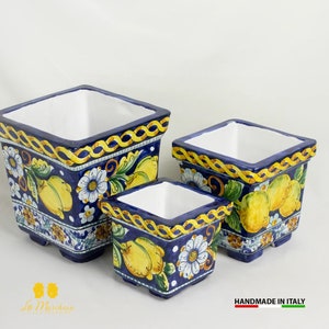 Può includere: Tre vasi quadrati in ceramica con fondo blu e bianco e limoni gialli e fiori bianchi. I vasi sono fatti a mano in Italia.