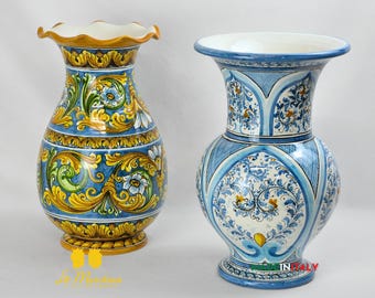 May include: Two decorative ceramic vases. The vase on the left has a ruffled rim and is painted with blue, yellow, and green floral patterns. The vase on the right is blue and white with a flared top and intricate designs. Both vases are on a white background.