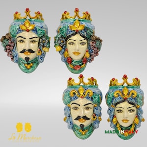 Puede incluir: Cuatro esculturas de cabeza de cerámica con coronas. Los rostros tienen detalles, incluyendo bigotes, detalles florales y joyas. La paleta de colores incluye verde azulado, dorado, rojo y crema. La frase "MADE IN ITALY" es visible.