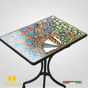 May include: A colourful ceramic table top with a geometric pattern, a wheel design, and cactus plants. The table top is on a black metal base. "HANDMADE IN ITALY" is printed on the base.