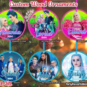 May include: Set of six 3-inch round wooden ornaments featuring characters from the TV show "Zombies 2". The ornaments are decorated with glitter and feature the names "Amanda", "Lorelei", "Eliana", "Sydney", "Addy", and "Evelyn".