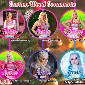 May include: Five 3-inch round wooden ornaments featuring a character from the film "Zombies" with the name "Anna" and the year "2024" printed on each ornament. The ornaments are decorated with glitter and feature different scenes from the film.