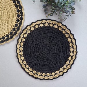 May include: Two crocheted placemats, one black with a gold border and one gold with a black border.