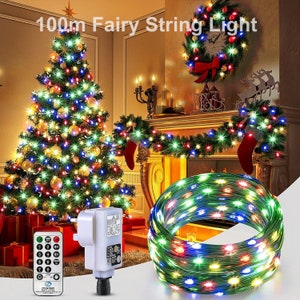 May include: 100m fairy string lights with multi-coloured bulbs wrapped around a Christmas tree and a fireplace. The lights are also coiled up in a circle. The lights are controlled by a remote.