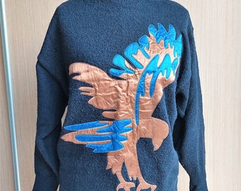 May include: A dark blue knitted sweater with a brown and blue eagle design on the front.