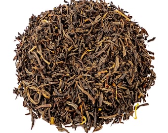 May include: A close-up of a pile of loose leaf black tea. The tea leaves are dark brown and have a slightly reddish hue.