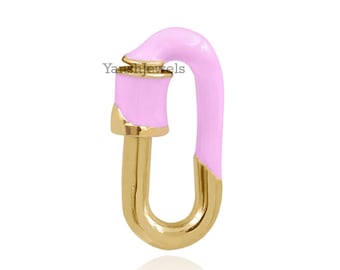 May include: A pink and gold-toned metal charm with a unique shape, resembling a stylized letter 'O' with a curved top. The charm is designed to be used as a connector for jewelry pieces.