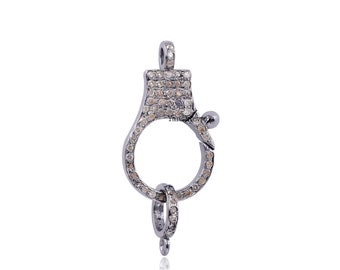 May include: Silver tone clasp with a round opening and a small loop. The clasp is decorated with small, clear diamonds.