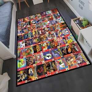 Puede incluir: Una alfombra colorida con un collage de cartuchos de juegos de Nintendo 64. La alfombra es negra con un borde rojo y presenta una variedad de juegos populares, incluyendo Mario Kart 64, Super Mario 64 y The Legend of Zelda: Ocarina of Time.