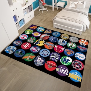 Może przedstawiać: Czarno-biały dywan z okrągłym wzorem logo drużyn NBA. Loga są w barwach swoich drużyn i obejmują Atlanta Hawks, Boston Celtics, Brooklyn Nets, Charlotte Hornets, Chicago Bulls, Cleveland Cavaliers, Dallas Mavericks, Denver Nuggets, Detroit Pistons, Golden State Warriors, Houston Rockets, Indiana Pacers, Los Angeles Clippers, Los Angeles Lakers, Memphis Grizzlies, Miami Heat, Milwaukee Bucks, Minnesota Timberwolves, New Orleans Pelicans, New York Knicks, Oklahoma City Thunder, Orlando Magic, Philadelphia 76ers, Phoenix Suns, Portland Trail Blazers, Sacramento Kings, San Antonio Spurs, Toronto Raptors, Utah Jazz, Washington Wizards.