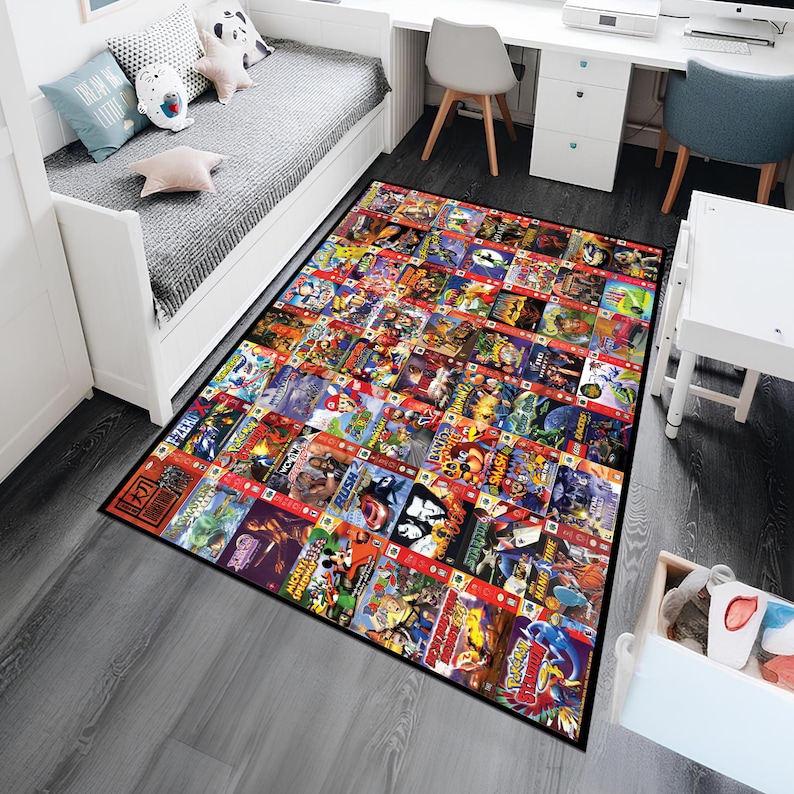 Puede incluir: Una alfombra de &aacute;rea negra y roja con un collage de cartuchos de juegos de Nintendo 64. La alfombra presenta una variedad de t&iacute;tulos populares, que incluyen Super Mario 64, The Legend of Zelda: Ocarina of Time y GoldenEye 007.