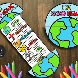 May include: A colorful educational craft featuring the text "THE GOOD NEWS John 3:16" and a world map design. The craft includes a pull-out section with Bible verses and illustrations. A variety of crayons are visible at the bottom of the image.