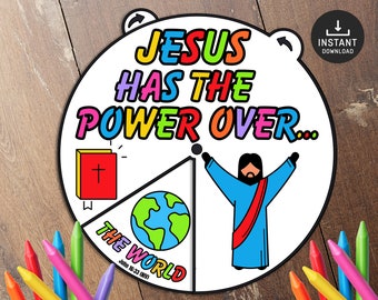 Op de afbeelding: Een kleurrijk, printbaar wiel met de tekst "Jezus heeft de macht over..." en drie secties: "De wereld", een rood boek met een kruis en een cartoon van Jezus met uitgestrekte armen.