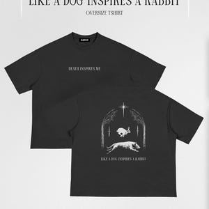 Puede incluir: Dos camisetas negras de gran tamaño con texto y gráficos blancos. Una camiseta muestra "DEATH INSPIRES ME" en la parte delantera. La otra camiseta presenta un perro persiguiendo a un conejo con el texto "LIKE A DOG INSPIRES A RABBIT".