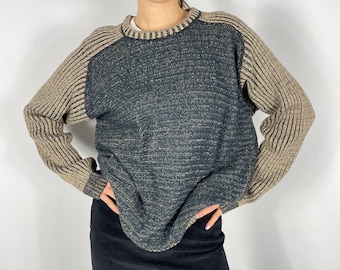 May include: A black and brown knit sweater with a textured pattern. The sweater has long sleeves and a crew neck.