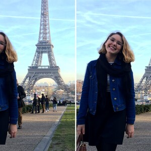 May include: A woman wearing a blue denim jacket, a black scarf, and a black skirt smiles in front of the Eiffel Tower in Paris, France.