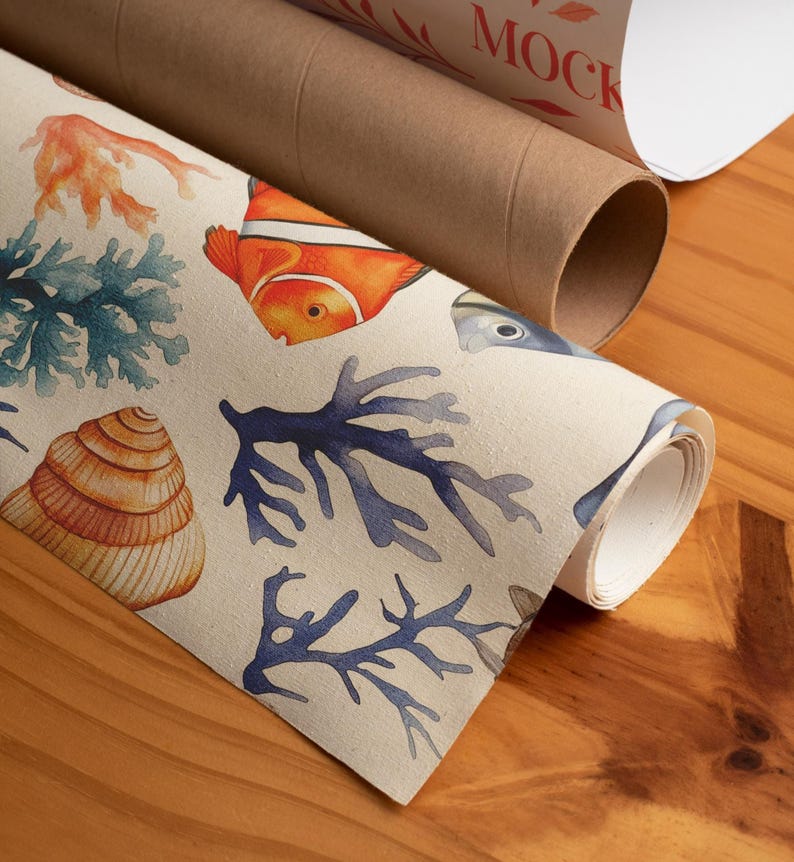 Op de afbeelding: Gerolde kunstdruk met een aquarelontwerp van zeeleven, waaronder een oranje clownvis, blauw koraal en een zeeschelp. De print staat op een beige achtergrond. Een bruine kartonnen koker is zichtbaar op de achtergrond met het woord "MOCK" erop gedrukt.