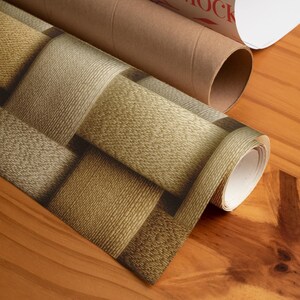 May include: Rolls of wallpaper with a woven basket design in shades of tan and brown. The wallpaper is partially unrolled, revealing the pattern. A brown cardboard tube is visible in the background.
