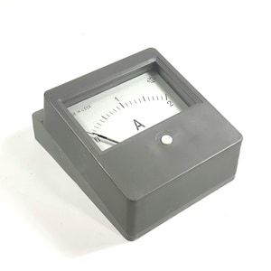May include: Grey analogue ammeter with a needle and a scale from 0 to 2. The face of the meter has the letter "A" and the text "MADE IN USSR". The meter is housed in a rectangular grey case.