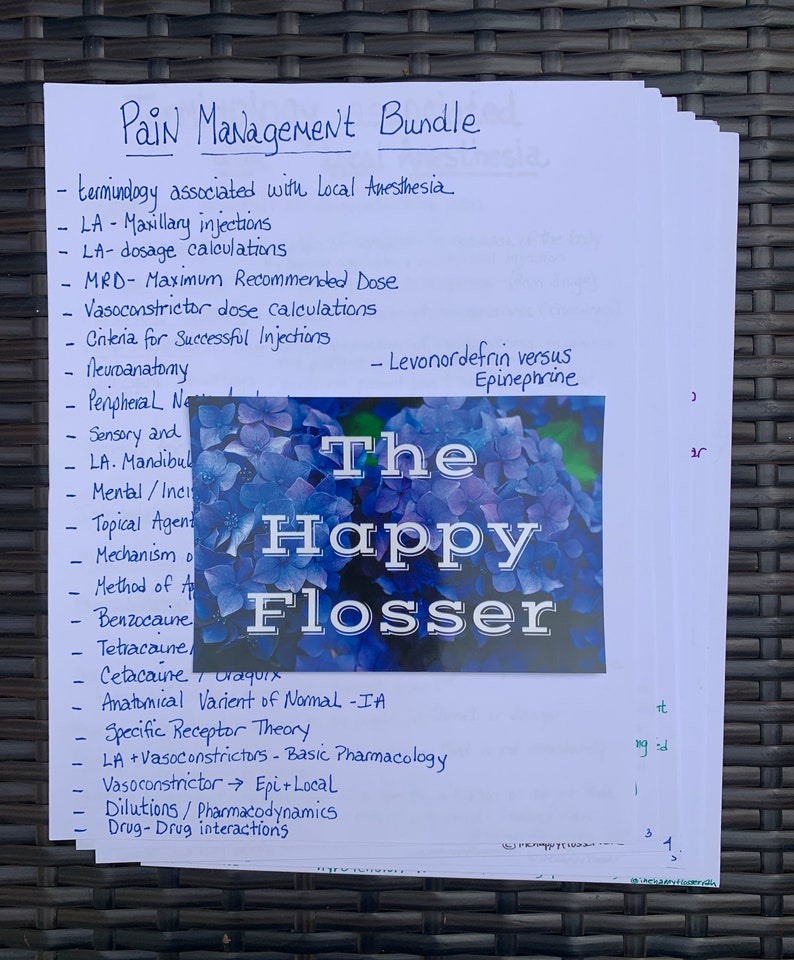 May include: A handwritten list of pain management topics, including terminology associated with local anesthesia, maxillary injections, dosage calculations, and vasoconstrictor dose calculations. The list is on a white sheet of paper with blue ink. The paper is partially covered by a blue and white floral pattern with the text "The Happy Flosser" in black.