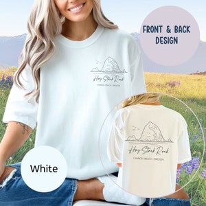 May include: White t-shirt with a black line drawing of Hay Stack Rock and the text "Hay Stack Rock Cannon Beach Oregon" on the front and back.