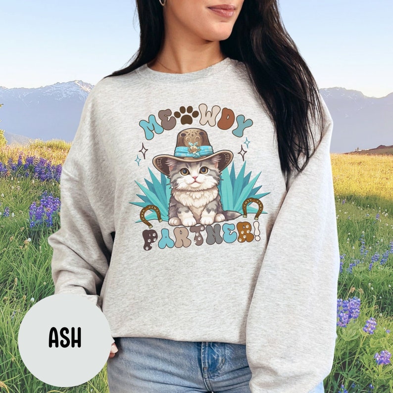 May include: A gray sweatshirt with a graphic of a cat wearing a cowboy hat and the text "MEOWDY PARTNER!" printed on it.