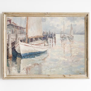 Op de afbeelding: Een antiek schilderij met een havengezicht. Een witte zeilboot met een blauwe streep ligt aangemeerd bij een houten pier. Andere zeilboten zijn in de verte te zien. Het schilderij heeft een gedempt kleurenpalet van blauw, wit en bruin.