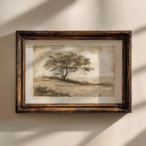 May include: A framed watercolor painting of a lone tree in a field. The painting is in shades of brown and beige, with a light background. The frame is a dark brown wood with a distressed finish.