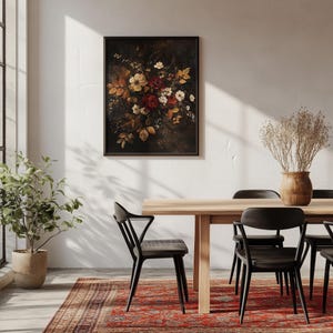 K&ouml;nnte beinhalten: Ein gerahmter Kunstdruck mit Blumen vor dunklem Hintergrund, der einen Strau&szlig; roter, wei&szlig;er und gelber Blumen zeigt. Das Kunstwerk befindet sich in einem Esszimmer mit einem Holztisch, schwarzen St&uuml;hlen und einem roten gemusterten Teppich.