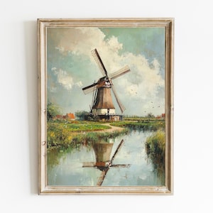 May include: A vintage oil painting depicting a windmill in a rural landscape. The windmill is painted in shades of brown and white, with a blue sky and green fields in the background. The painting is framed in a light wood frame.