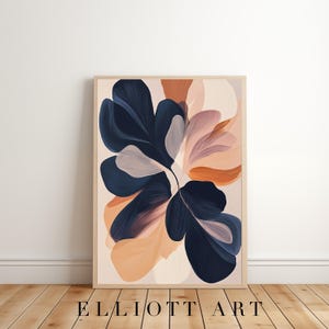 May include: Abstract floral art print in a wooden frame. The artwork features large, stylized flower shapes in navy blue, peach, and light pink hues against a cream background. The text "ELLIOTT ART" is printed at the bottom.