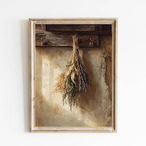 Op de afbeelding: Een ingelijste print met een bos gedroogde kruiden die aan een houten balk hangt. De kruiden, waaronder lavendel, zijn in tinten groen, bruin en paars. De achtergrond is een getextureerde muur, wat een rustieke uitstraling creëert.