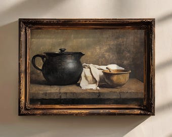 Puede incluir: Pintura enmarcada de naturaleza muerta con una jarra de cerámica negra con tapa, un cuenco de madera y un paño blanco. La pintura tiene una paleta de colores oscuros y apagados y está ambientada sobre un fondo texturizado. El marco es marrón oscuro con detalles dorados.