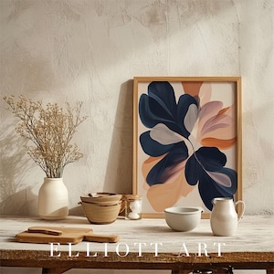 May include: A framed art print featuring an abstract floral design in navy, peach, and blush tones. The artwork is displayed on a wooden table alongside a vase, bowls, and a pitcher. The text "ELLIOTT ART" is at the bottom.