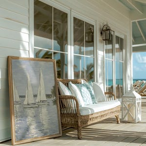 May include: A coastal scene featuring a framed sailboat painting, a wicker loveseat with white and blue pillows, and a white lantern. The setting is a porch with large windows and a view of the ocean.