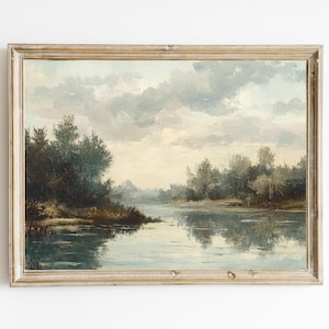 May include: A framed landscape painting depicting a river scene with trees on either side of the water. The sky is a light blue with white clouds. The water is a light blue with reflections of the trees and clouds.