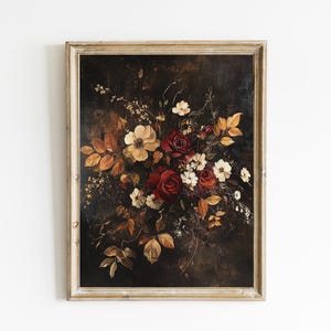 K&ouml;nnte beinhalten: Gerahmtes Blumenstillleben-Gem&auml;lde. Das Kunstwerk zeigt einen dunklen Hintergrund mit einem Bouquet aus Rosen und anderen Blumen in Rot-, Wei&szlig;- und Gelbt&ouml;nen, mit braunen und goldenen Bl&auml;ttern. Der Rahmen ist hell und neutral.