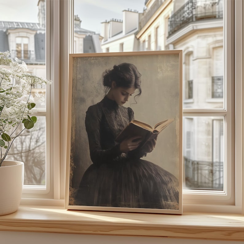 May include: A framed vintage-style photograph of a woman in a dark dress reading a book. The background is a blurry image of a city.