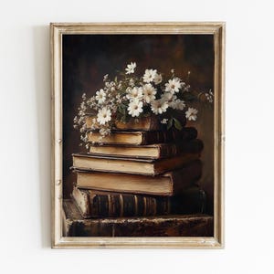 May include: A framed painting of a still life featuring a stack of antique books with a bouquet of white daisies on top. The books are arranged in a pyramid shape and have a worn, aged look. The daisies are delicate and have a soft, white color.