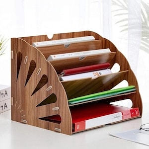 May include: A wooden desktop organizer with five compartments for storing files, papers, and other office supplies. The organizer has a fan-shaped design with cutouts on the front.