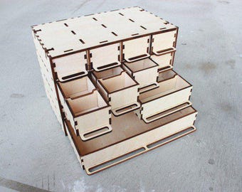 May include: A wooden organizer with multiple drawers, perfect for storing small items. The organizer is made of light-colored wood and has a simple, modern design.