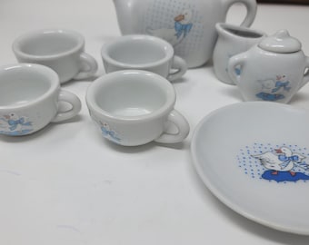 May include: A white porcelain miniature tea set with a teapot, creamer, sugar bowl, cups, and a saucer. Each piece is decorated with a blue and white goose design. The set is suitable for children's play or display.