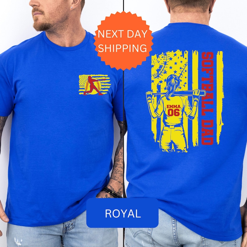 May include: A royal blue t-shirt with a yellow and red softball player graphic on the front and a yellow and red American flag with the text "Softball Dad" on the back. The player is holding a bat and has the name "Emma" and the number "06" on her jersey.
