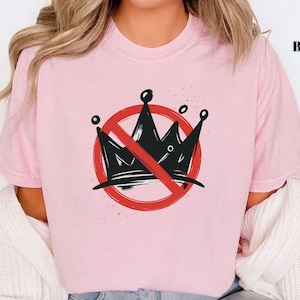 Pode incluir: Camiseta rosa claro com um desenho de coroa preta dentro de um c&iacute;rculo vermelho com uma linha diagonal. A palavra "BLOSSOM" est&aacute; impressa em preto no canto superior direito. O design &eacute; uma declara&ccedil;&atilde;o.