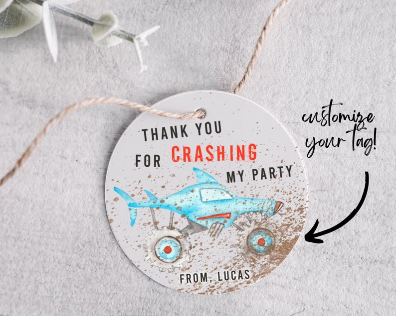 May include: Round thank you tag with a blue and white monster truck with shark fins. The tag has the text "Thank you for crashing my party" and "From, Lucas".