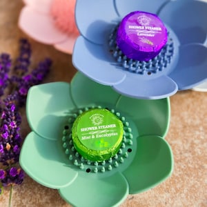 May include: Three shower steamers in flower-shaped holders. The steamers are wrapped in foil and have different scents: Lavender, Mint & Eucalyptus.