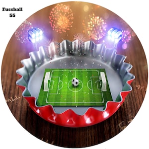 Könnte beinhalten: Ein grünes Fussballfeld mit einem weißen Fussball in der Mitte, in einem roten und silbernen Flaschenverschluss. Feuerwerk explodiert im Hintergrund.