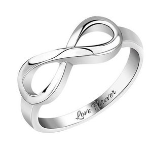 Op de afbeelding: Een zilveren oneindigheidsring met de woorden "Love Forever" gegraveerd op de band.