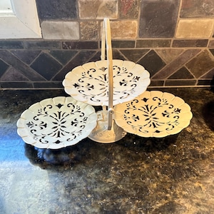 May include: A set of three ceramic mugs with a speckled, matte finish. The mugs are in shades of cream, light gray, and dark gray. Each mug has a simple, minimalist design, perfect for coffee or tea.