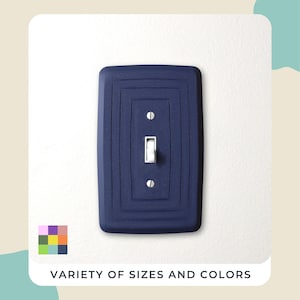 May include: A navy blue light switch cover with a rectangular design, mounted on a white wall. The switch is white. The text "VARIETY OF SIZES AND COLORS" is at the bottom of the image.